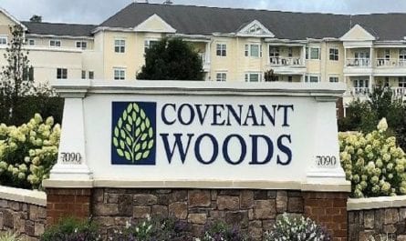 Covenant Woods sign and buildings in the background